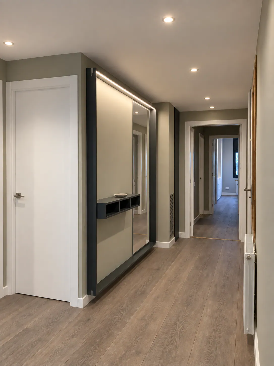 BiG entryway hallway with built-in floating mirror unit, recessed spotlights and white doors