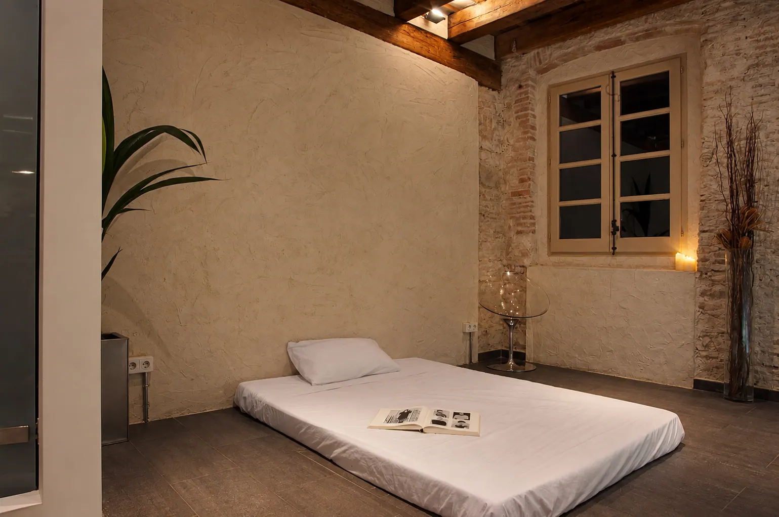 OLi bedroom with floor mattress and exposed brick walls