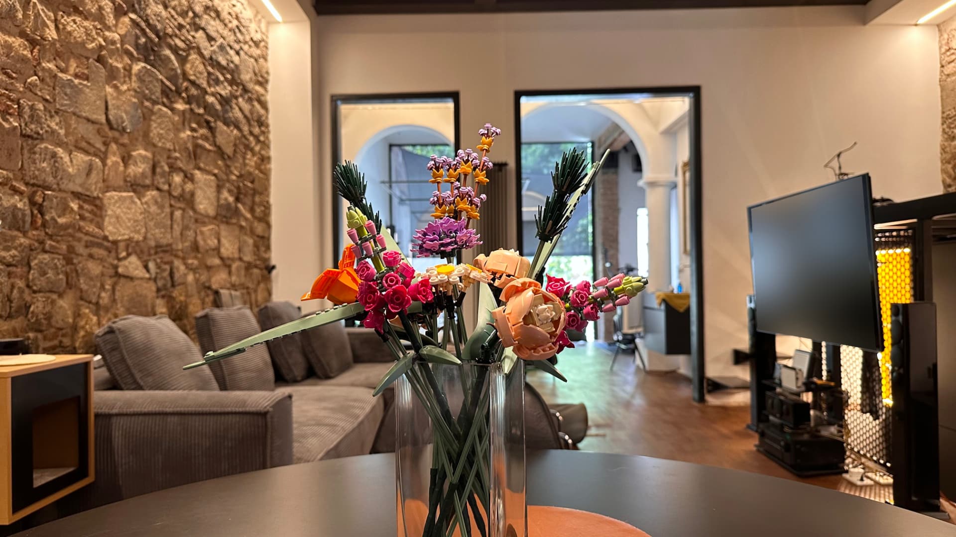 AuL living room with flowers and exposed stone wall