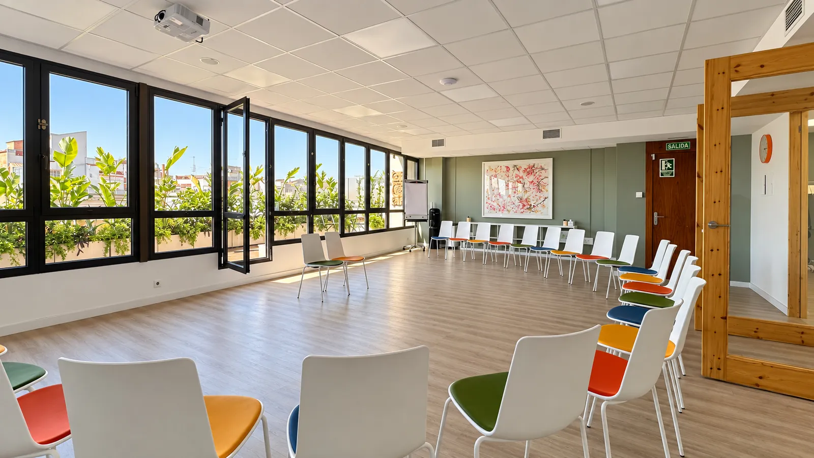 GlG training room with folding windows opening onto the planted terrace and a ceiling projector