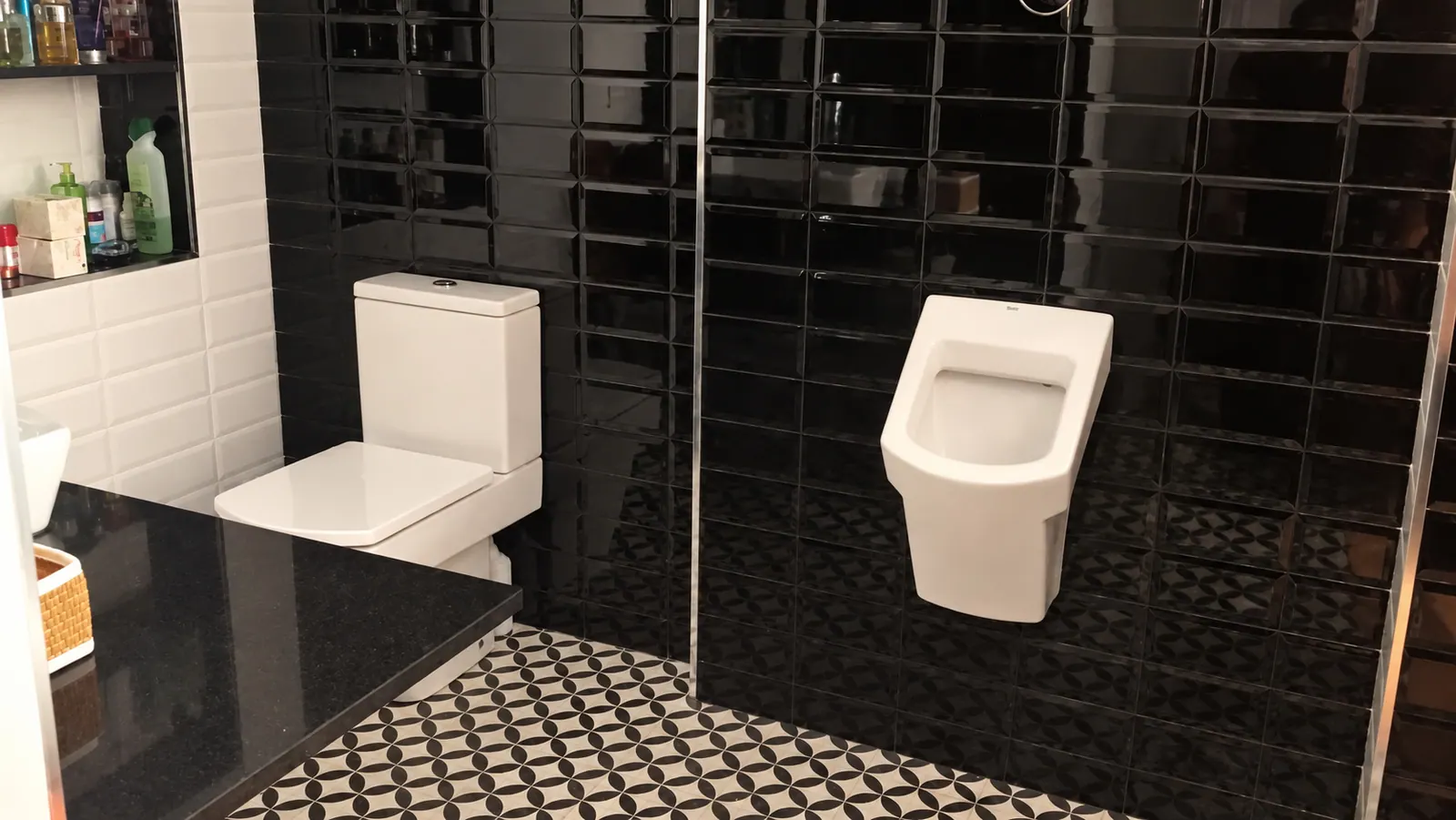 TrF black-tiled bathroom with white fittings and patterned floor tiles