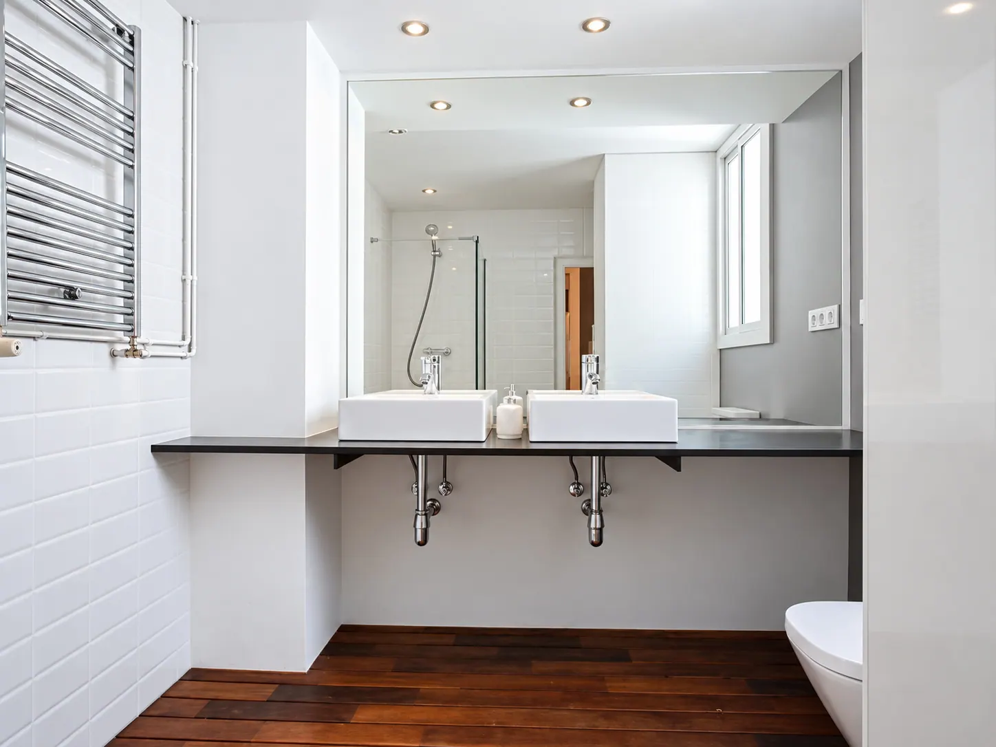 LLn bathroom with twin basin shelf, wall-length mirror, chrome towel rail and timber floor
