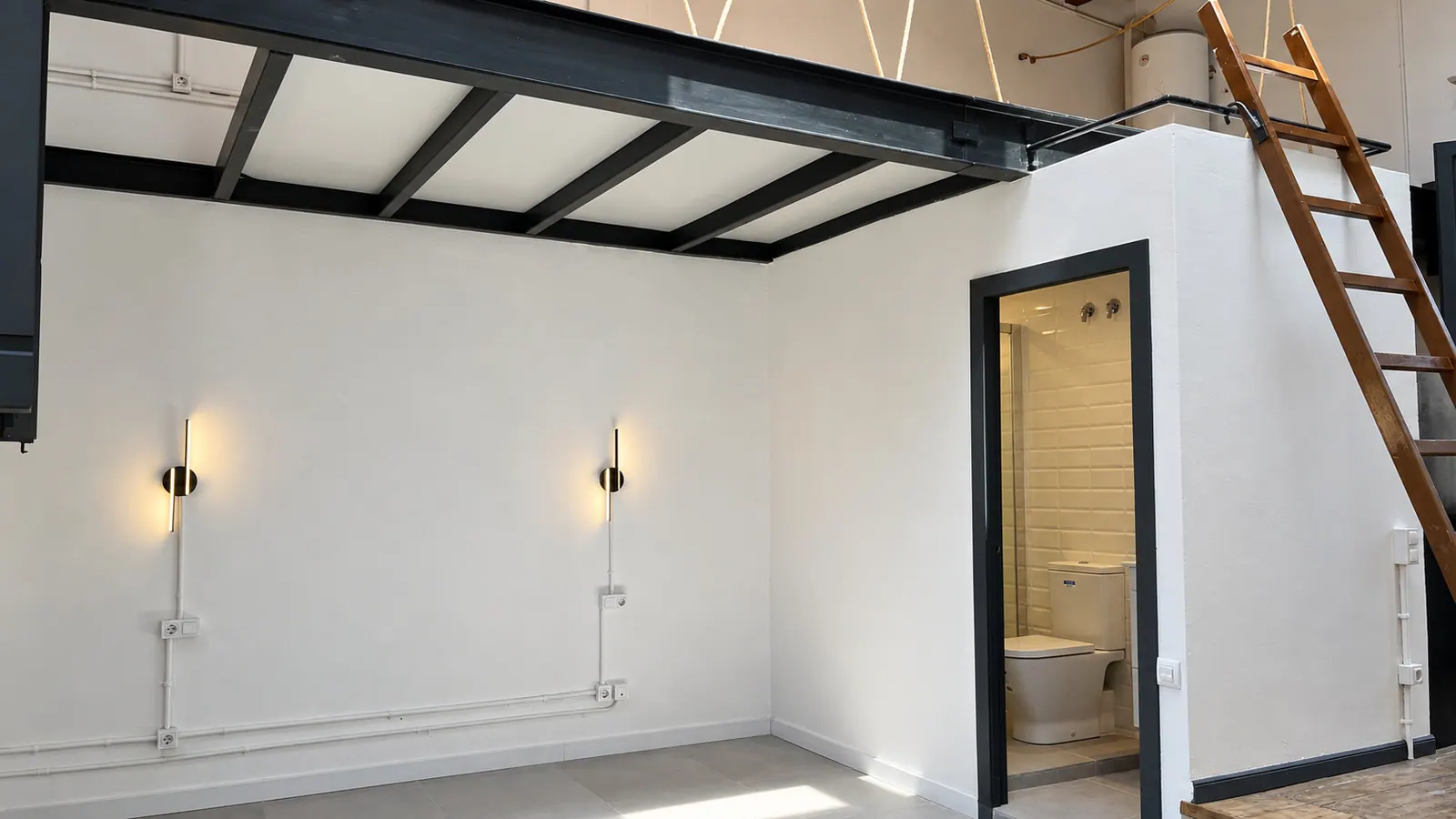 AiP third-floor studio with steel loft frame and ladder