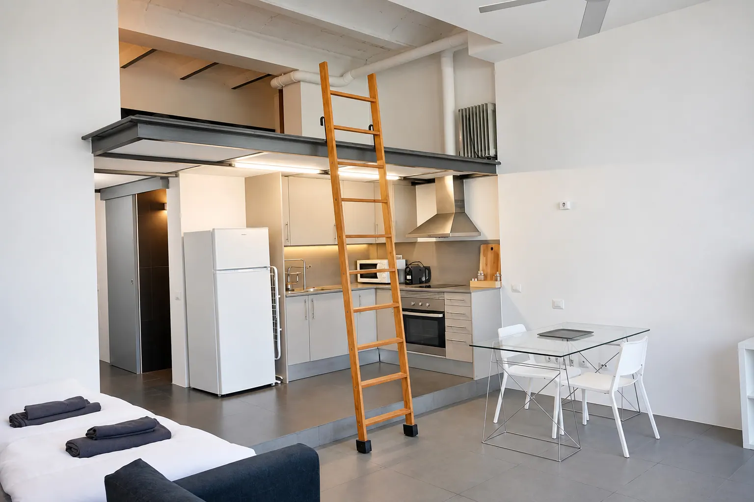 FoL Apartment 02 compact kitchen with white refrigerator and wooden ladder to the loft