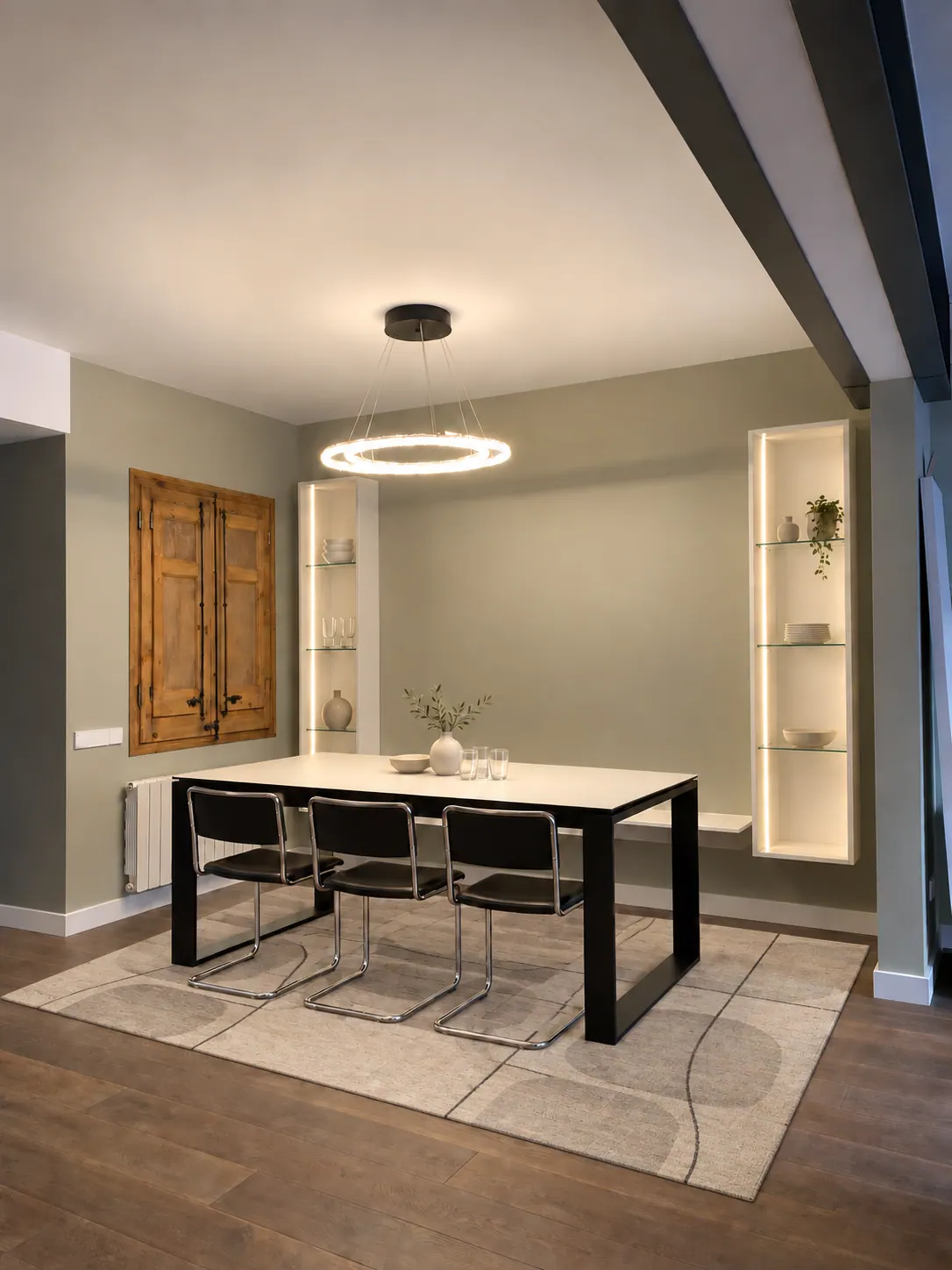 BiG dining area with white table, black cantilever chairs and halo LED chandelier over a patterned rug