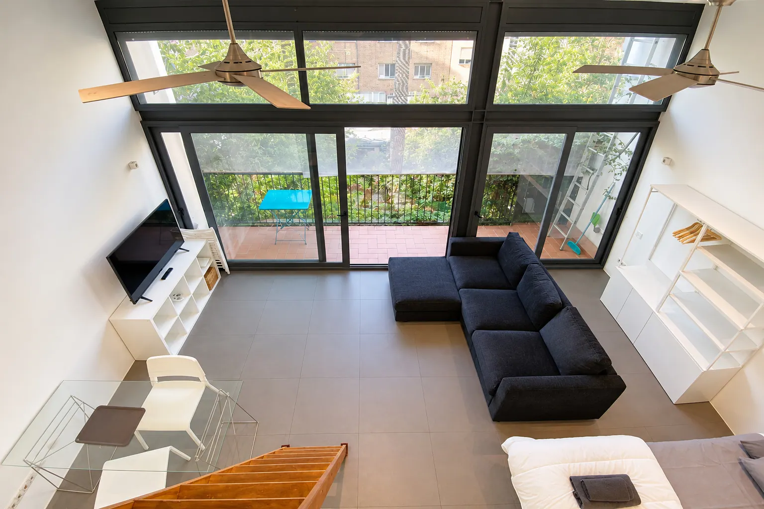 FoL Apartment 02 high-angle view from the loft over the sofa, TV console, and balcony access