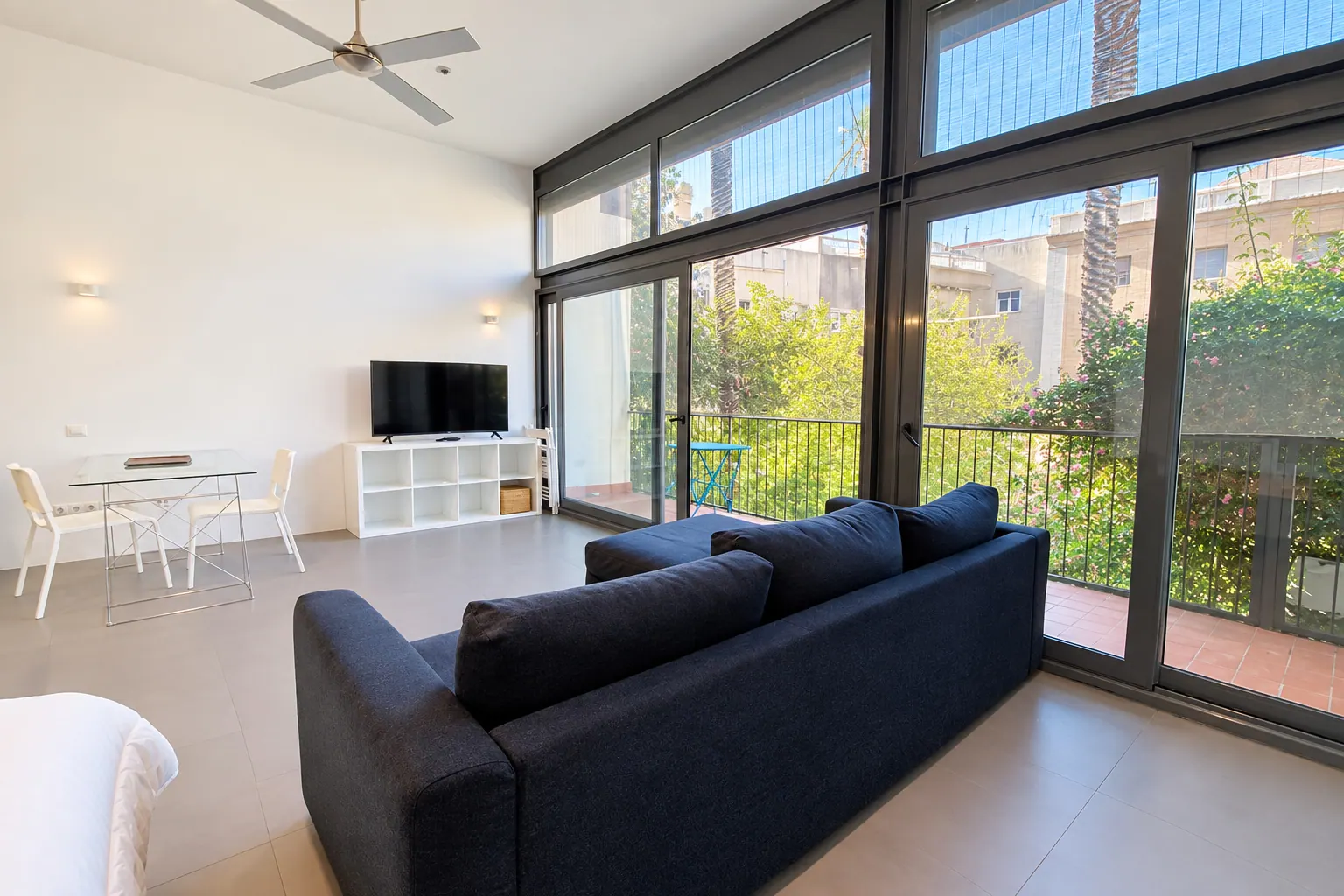 FoL Apartment 02 TV area and glass dining table beside floor-to-ceiling windows